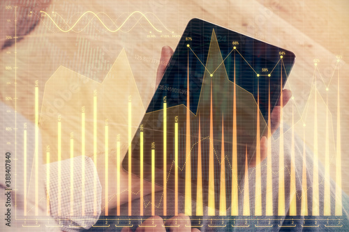 Double exposure of man s hands holding and using a digital device and forex graph drawing. Financial market concept.