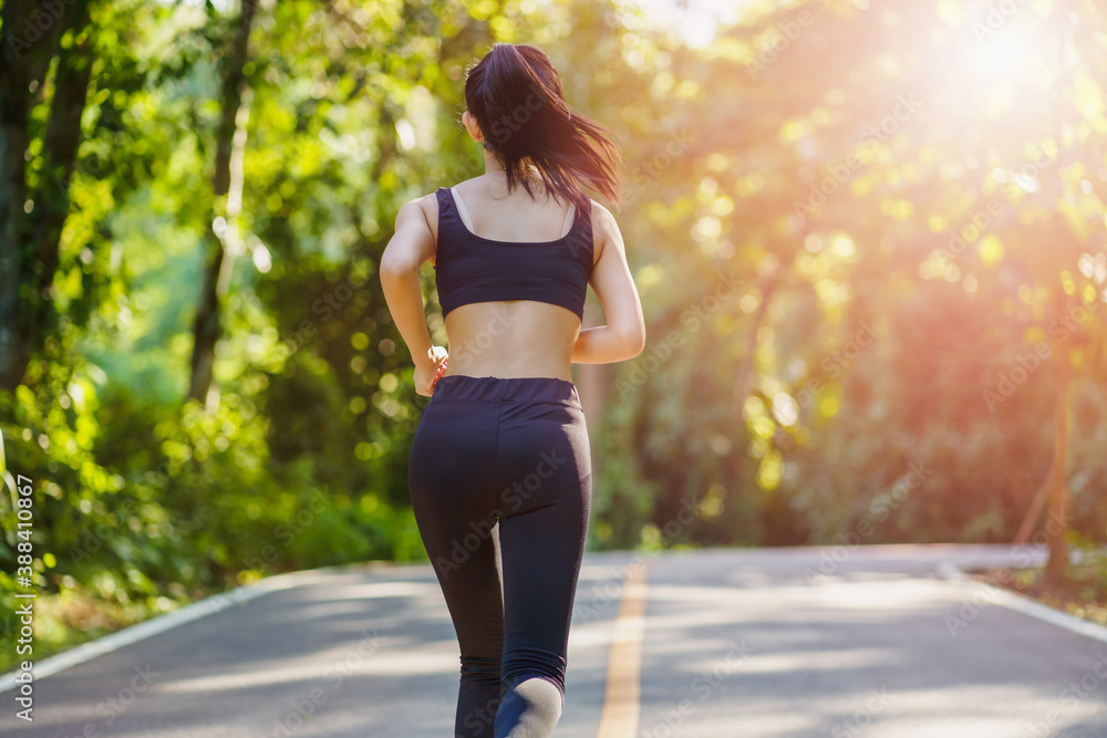 Young fitness woman in sports clothing running while exercising outdoors at morning.. Young fitness woman in sports clothing running while exercising outdoors at morning..
