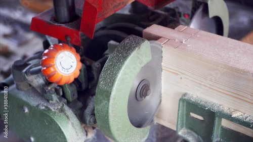 A tenon saw is used to cut the wooden plank in carpenter workshop. Close view