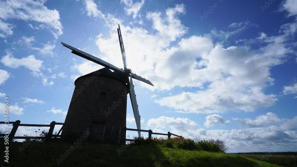 Rotating windmill, blue sky and white clouds background, wind power concept Rotating windmill, blue sky and white clouds background, wind power concept