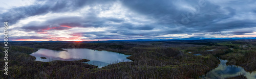 Panoramic View of Scenic Lake surrounded my Mountains and Forest at Sunrise in Canadian Nature. Aerial Drone Shot. Northern British Columbia, Canada.