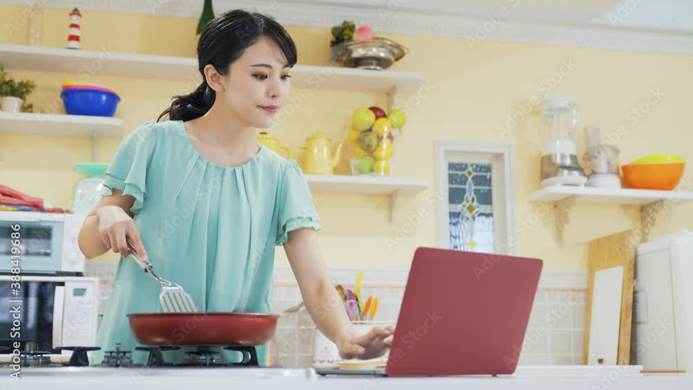 パソコンを見ながら料理する女性 レシピ動画 レシピサイト パソコンを見ながら料理する女性 レシピ動画 レシピサイト