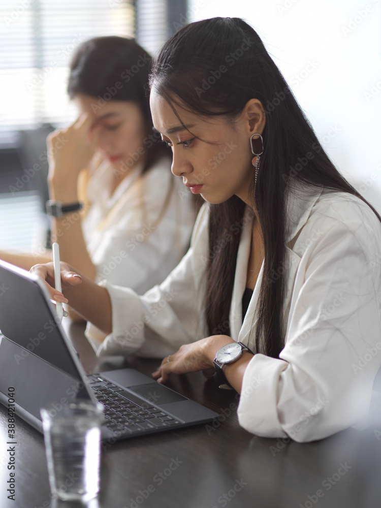 Businesswomen team working on their project together in office room Businesswomen team working on their project together in office room