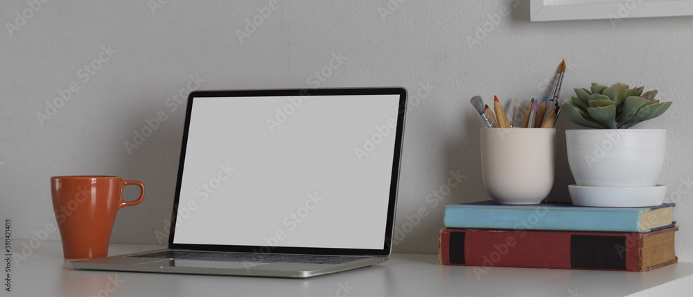 Obraz premium Workspace with mock up blank screen laptop computer with office supplies, clipping path