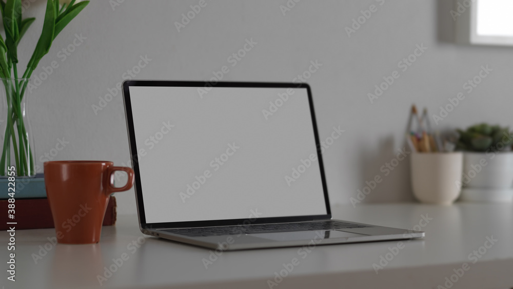 Mock up laptop computer with office supplies in workspace Mock up laptop computer with office supplies in workspace