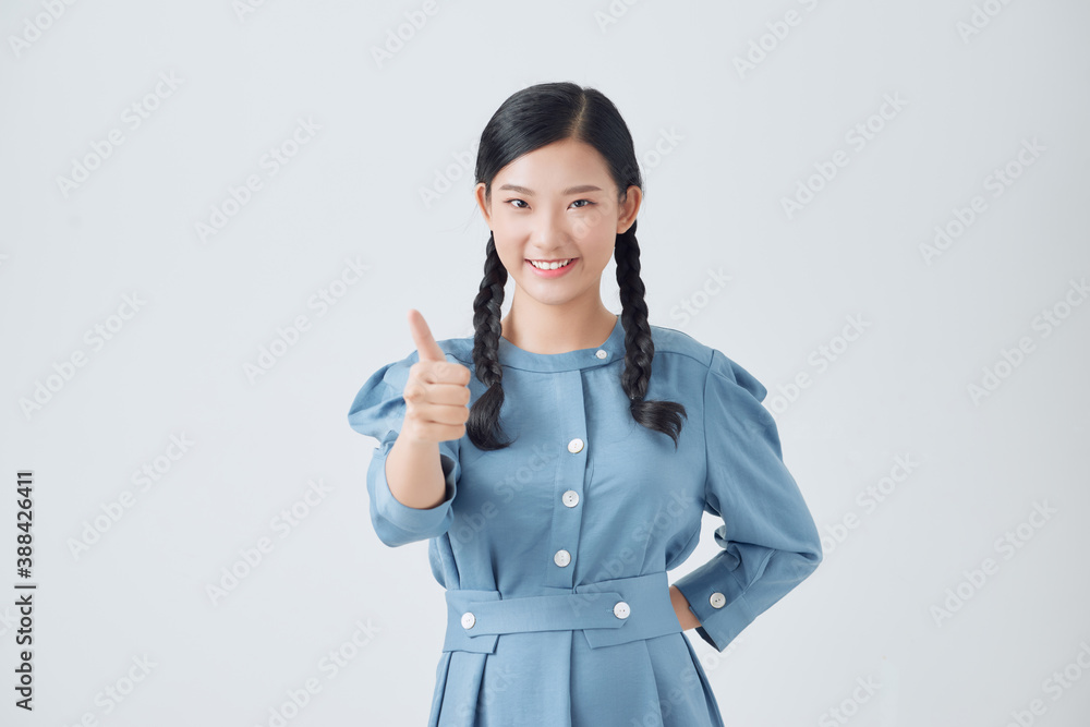 Excited pretty asian teenager holding thumbs up isolated over white background. Concept of positive evaluation. Excited pretty asian teenager holding thumbs up isolated over white background. Concept of positive evaluation.