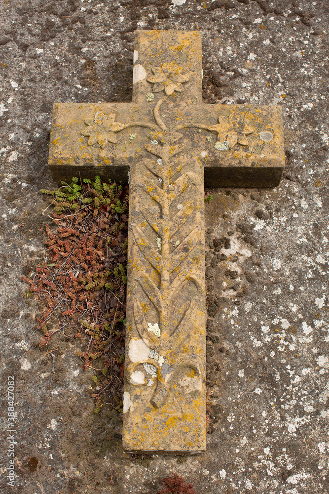 View of a cross lying on the ground of a grave in an old rural cemetery