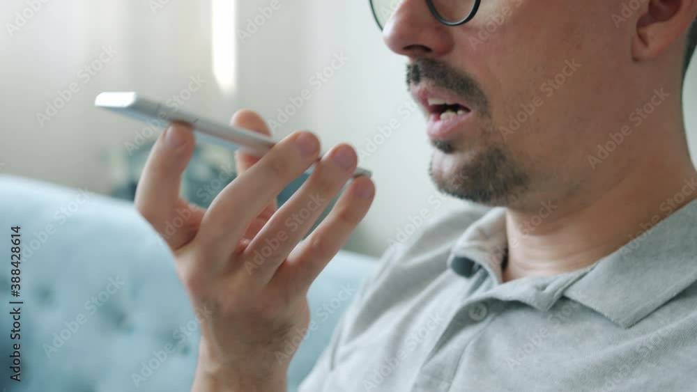 Slow motion of guy busy with online communication texting recording voice messages with smartphone at home. Modern devices and people concept. Slow motion of guy busy with online communication texting recording voice messages with smartphone at home. Modern devices and people concept.