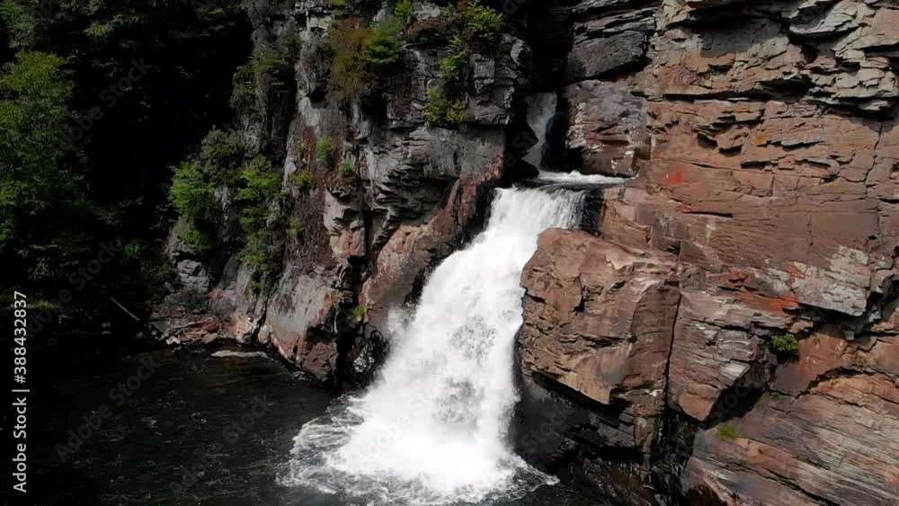 Slowmotion zoom out view of river cascading through rocks in the middle of the forest Slowmotion zoom out view of river cascading through rocks in the middle of the forest