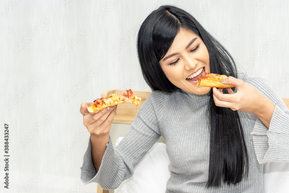 Beautiful woman eating delicious pizza on bed. Beautiful woman eating delicious pizza on bed.