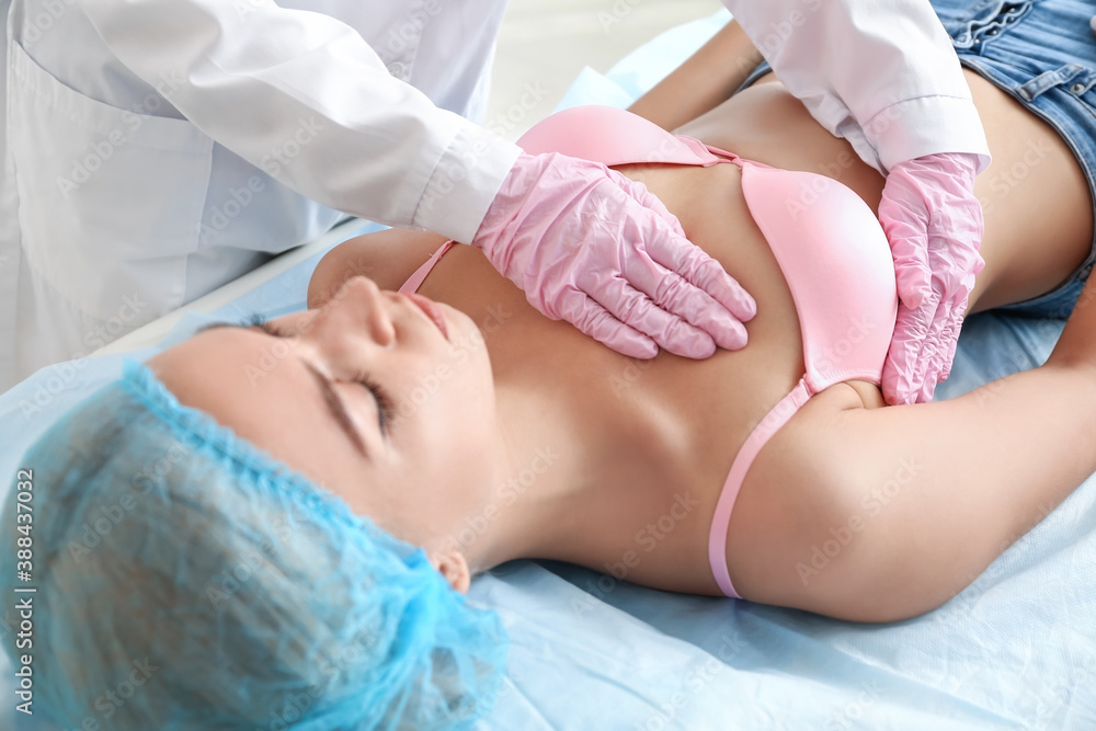 Mammologist examining young woman in clinic. Breast cancer awareness Mammologist examining young woman in clinic. Breast cancer awareness