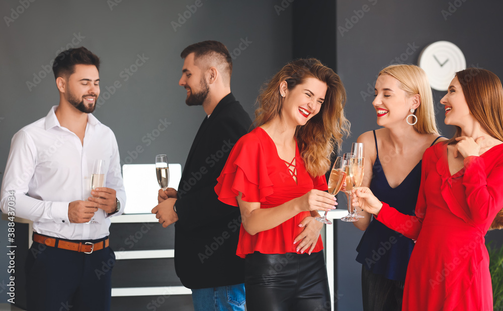 Fototapeta premium Young people drinking tasty champagne at party in office