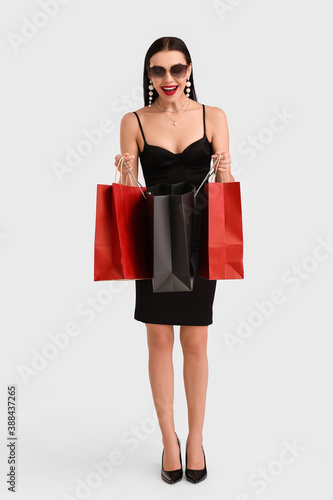 Beautiful young woman with shopping bags on white background. Black Friday sale