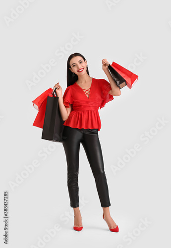 Beautiful young woman with shopping bags on white background. Black Friday sale