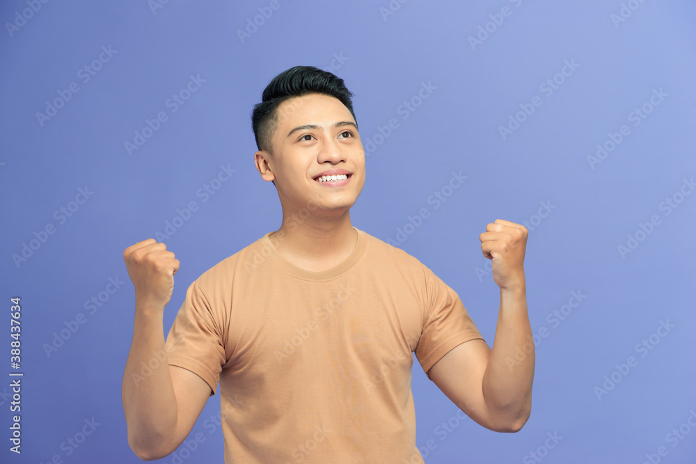 Young handsome man celebrating surprised and amazed for success with arms raised Young handsome man celebrating surprised and amazed for success with arms raised