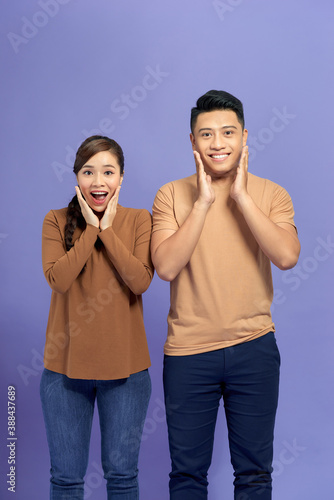Image of happy friends loving couple standing isolated over purple background screaming looking camera.