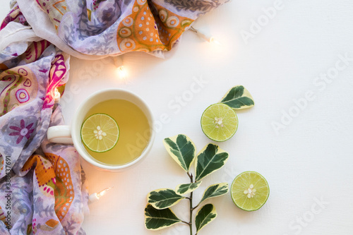 herbal mix honey lemon hot healthy drinks for sore throat with scarf of lifestyle woman relax in winter season and decorate light on background white
