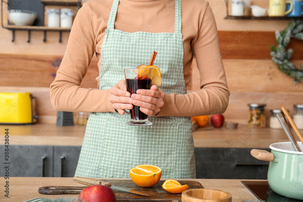 Woman making tasty mulled wine at home