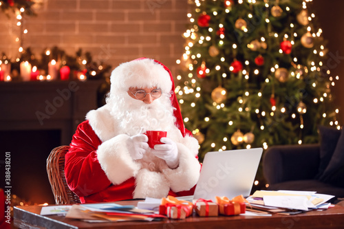 Santa Claus with laptop che...