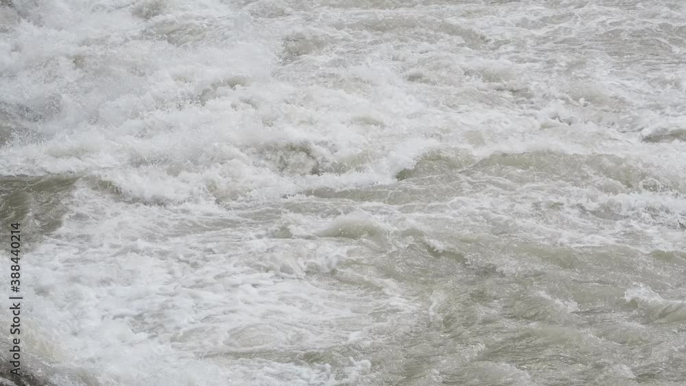 The river swollen after heavy rainfall and floodwater crashing through valley. The water flows fast from the high valley to the plain. General contest of a river in flood The river swollen after heavy rainfall and floodwater crashing through valley. The water flows fast from the high valley to the plain. General contest of a river in flood