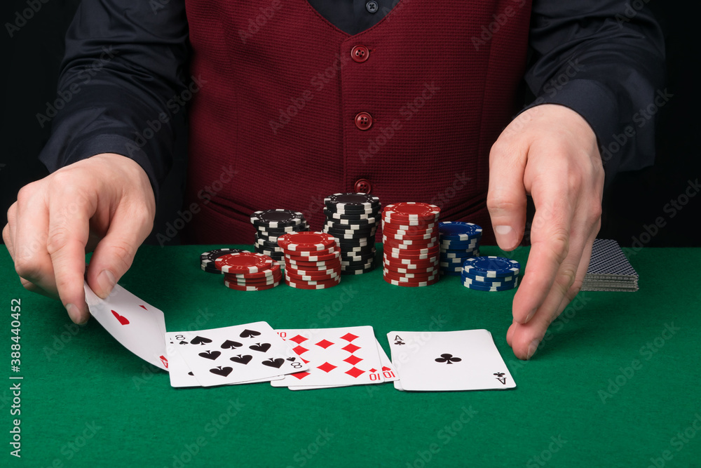 the croupier at the green table removes the playing cards for poker the croupier at the green table removes the playing cards for poker