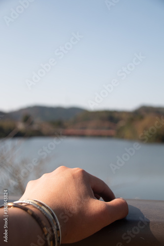 湖を眺める男性の手。主観視点。思い出、記憶、黄昏イメージ写真素材