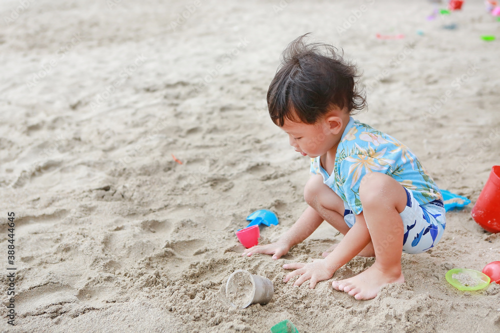 Portrait of little asian baby boy play sand with toys on beach Portrait of little asian baby boy play sand with toys on beach