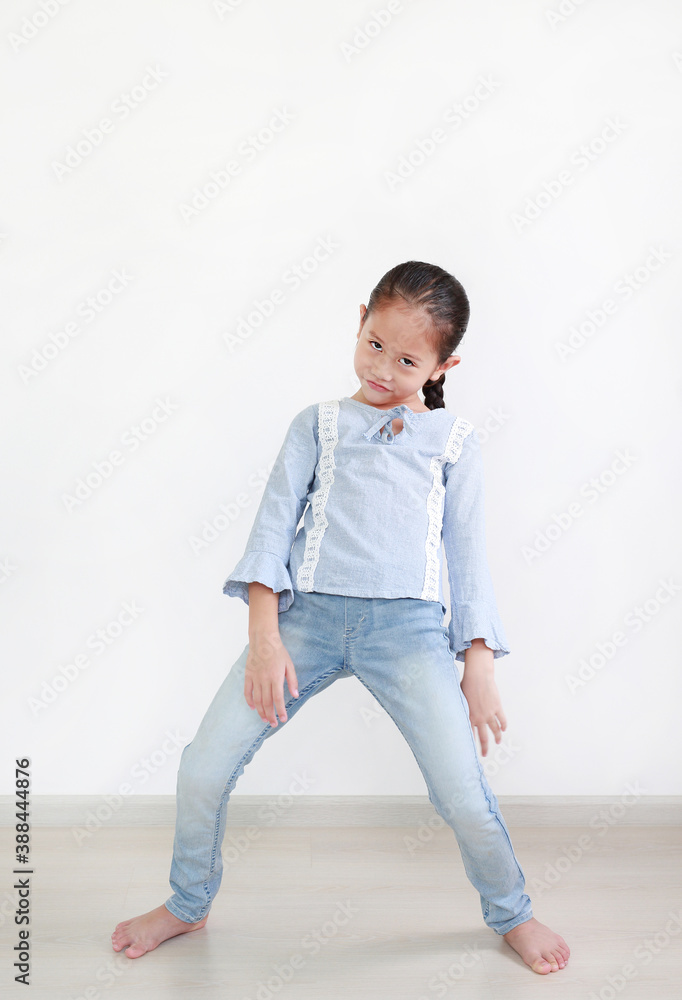 Funny face expression asian little child girl in white room. Full length. Funny face expression asian little child girl in white room. Full length.