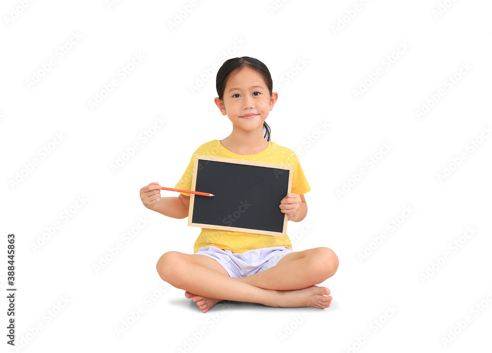 Asian little kid girl sitting and holding color pencil point on blackboard isolated on white background Asian little kid girl sitting and holding color pencil point on blackboard isolated on white background
