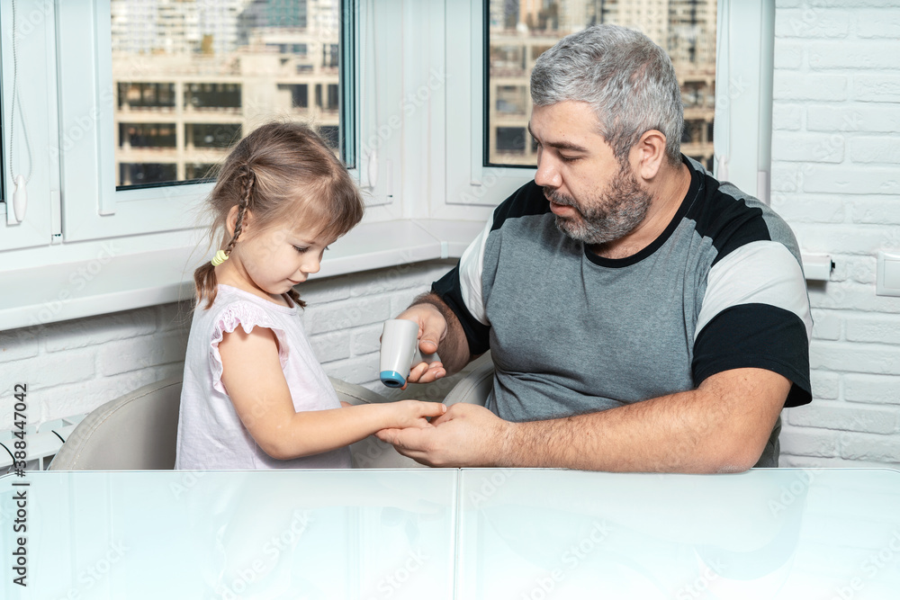 Fototapeta premium dad measures 4 year old daughter's body temperature