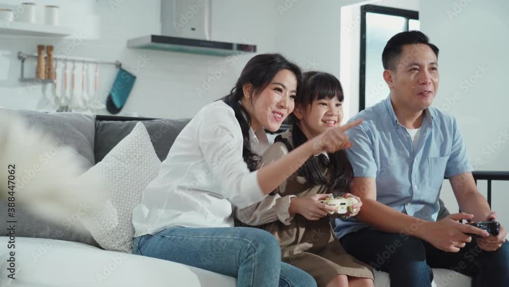 Asian father and daughter with family playing game in the living room. Asian father and daughter with family playing game in the living room.