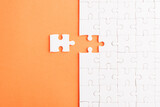 Top view flat lay of paper plain white jigsaw puzzle game texture last pieces for solve and place, studio shot on an orange background, quiz calculation concept