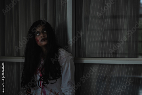 Horror evil woman ghost creepy in a dark room at house. The female devil is scary she haunted at the abandoned building, Happy Halloween day concept.