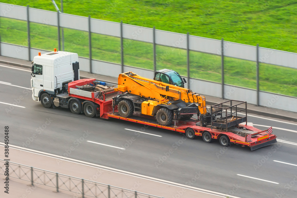 Truck with a trailer platform transports equipment with an elevator car platform, hydraulic and mechanical.