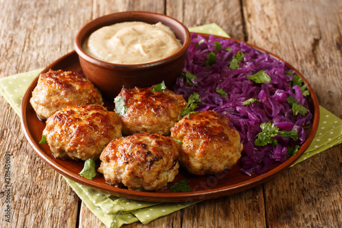Canvastavla Delicious fried meatballs with hot stewed red cabbage and sauce close-up in a plate on the table