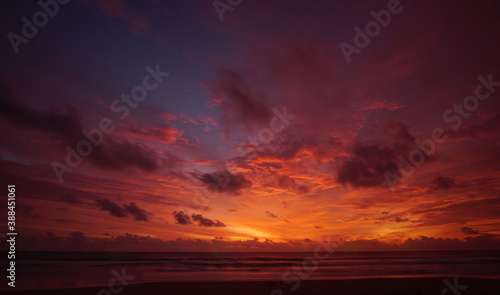 Nature background. Shot of Landscape amazing of red sky sunset in the sea with red clouds background. Travel concept. © BUDDEE