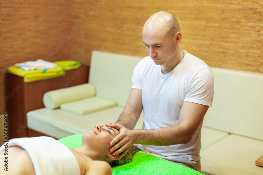 Fototapeta premium Close up of beautiful young woman relaxing with face massage at beauty spa