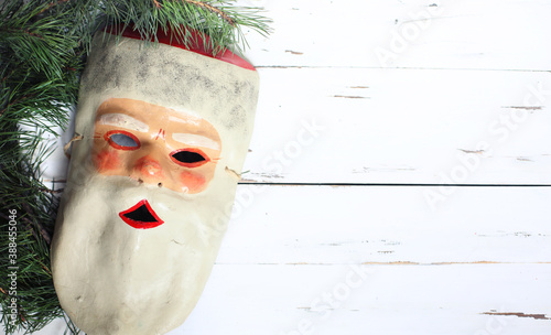 Foto Old vintage retro papier mache ugly/unusual mask of Santa Claus on white wooden background