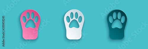 Paper cut Paw print icon isolated on blue background. Dog or cat paw print. Animal track. Paper art style. Vector.