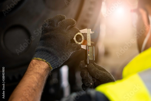 Papier peint Hand of technician wearing cloth gloves was using a digital vernier tool to measure the width of the nut