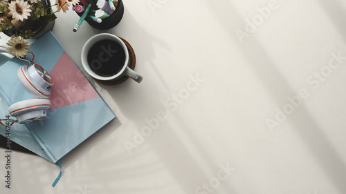 Top view with pastel notebook, coffee cup, headphone and copy space on wooden table. photo