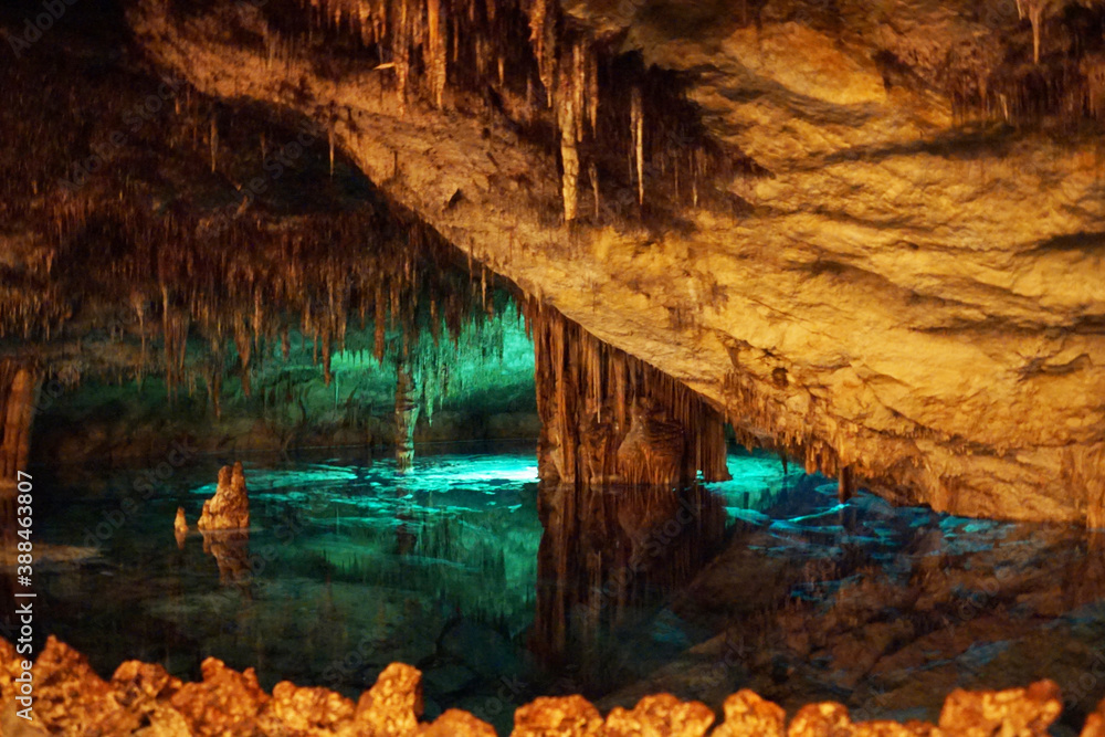 famous dragon caves on Majorka island. Beautiful transparent turquoise water in underground lake, surrounded with stalactites and stalagmites. Place of tourists attraction