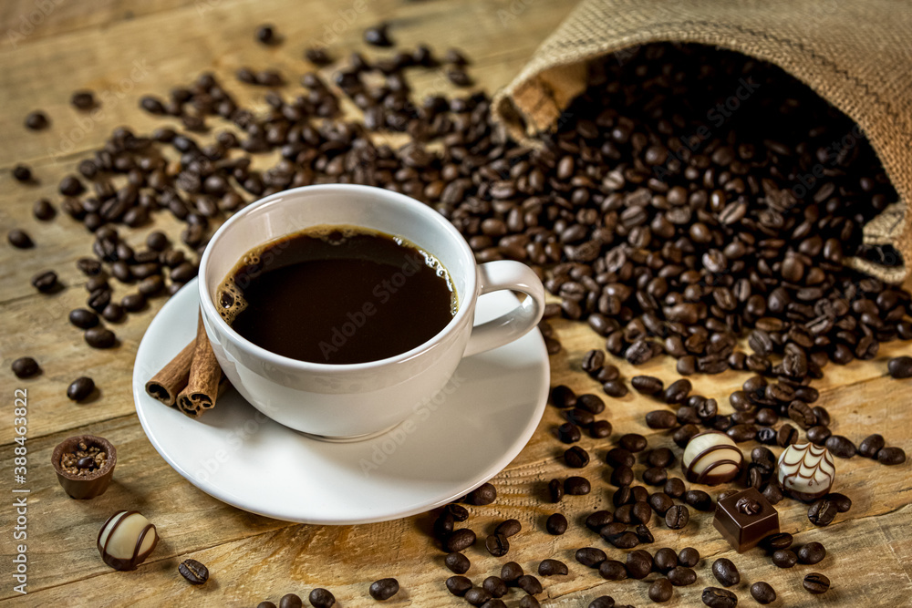 Dark coffee on a wooden table with coffee beans and chocolates Dark coffee on a wooden table with coffee beans and chocolates