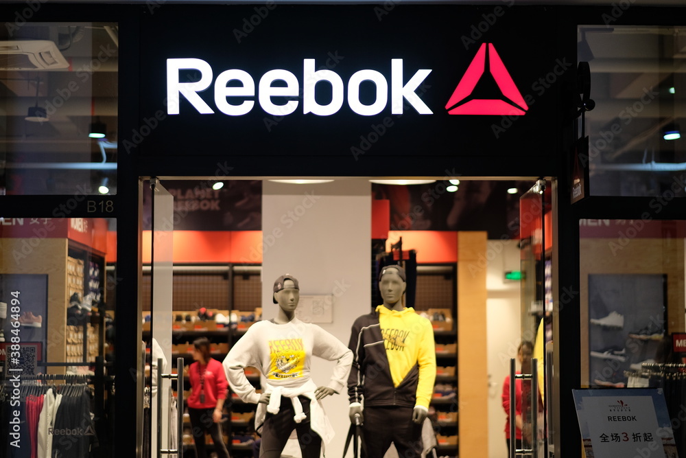 Shanghai/China-Oct.2019: facade of Reebok clothing store in Florentia  Village Outlets. White brand logo.Illuminated clothing store inside. An  American sports brand. Stock Photo | Adobe Stock