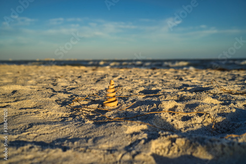 Deko Objekt  Spirale aus Holz am Strand  Sonnenschein  Horizont und Wasser im Hintergrund