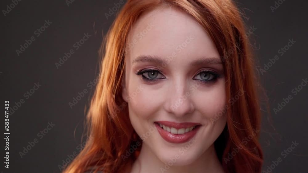 Red-haired woman 25-30 years old face close-up. Smile with teeth. Advertising of skin care products. Expression wrinkles. Shots under the eyes. Aging makeup. Red-haired woman 25-30 years old face close-up. Smile with teeth. Advertising of skin care products. Expression wrinkles. Shots under the eyes. Aging makeup.