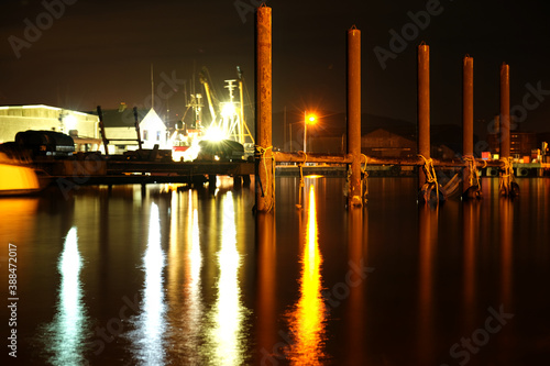 Tyres and rope hanging on metal post in Arklow harbour at night photo