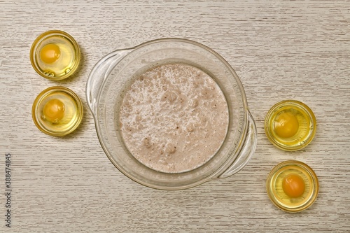 A bowl of fermented diluted yeast four round containers in each of the broken eggs. photo