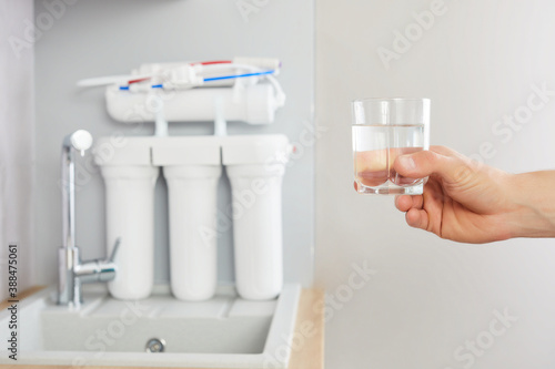 Obraz na plátně Men's hand holds a glass of clear water