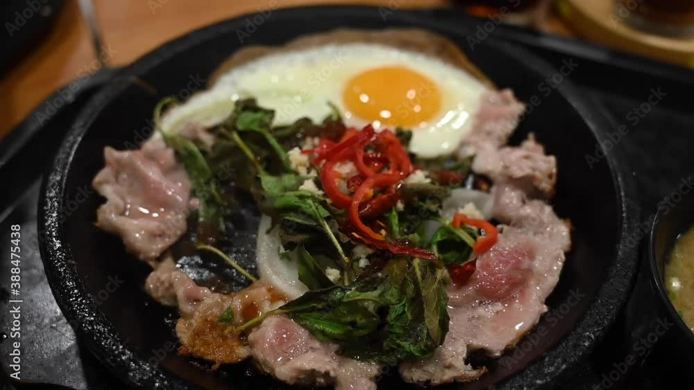 Pork basil rice in a hot pan with smoke in the dining table Pork basil rice in a hot pan with smoke in the dining table